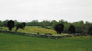 an image of a small grass hill walled by stone